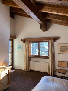 ein Schlafzimmer mit einem Bett und einem Fenster in der Unterkunft Chalet mit Blick auf den Gotschna in Klosters
