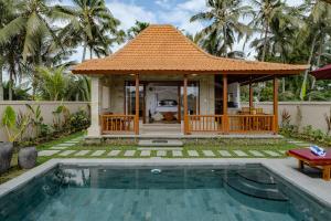 a villa with a swimming pool and a house at Prabawa Ubud Villa in Ubud