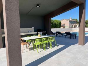 a patio with a table and chairs on a patio at Villa Cedrus in Juršići
