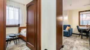 a room with a bed and a table and a chair at Apartament Widok Krynica Morska z widokiem na morze in Krynica Morska +8 photos