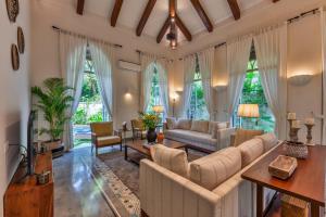 a living room with white furniture and large windows at Villa Lluvia 5bhk-Huge Pvt Pool-Caretaker-Bathtub-Big Garden-Genset Backup- Siolim in Oxel