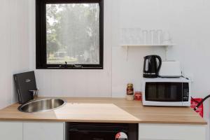 a kitchen with a sink and a microwave on a counter at Schlaraffenland 2 by Tiny Away in Chatsworth Island