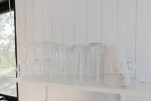 a shelf filled with clear glass jars on a wall at Schlaraffenland 2 by Tiny Away in Chatsworth Island +19 photos