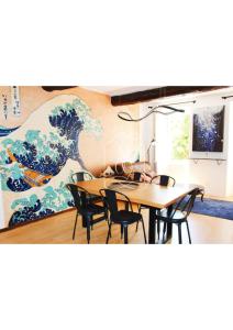 a dining room with a large painting on the wall at La Vague, au coeur du village de Montauroux in Montauroux
