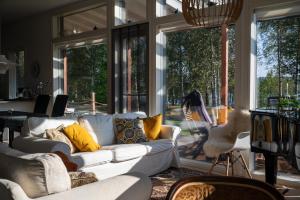 a living room with a white couch and large windows at Villa Puistola & sauna, near Santa's Village in Rovaniemi