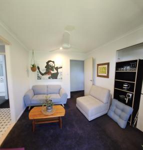 a living room with two couches and a coffee table at Bushland View Retreat in Ocean Shores