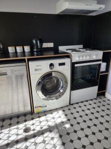 a kitchen with a washing machine and a stove at Bushland View Retreat in Ocean Shores