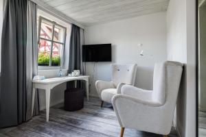 ein Hotelzimmer mit Schreibtisch und zwei Stühlen in der Unterkunft Flair Hotel zum Storchen in Bad Windsheim