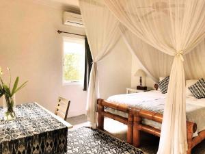 a bedroom with a canopy bed and a table at Large Private Villa, central Seminyak, Bali in Seminyak