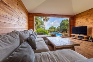 ein Wohnzimmer mit einer Couch, einem Tisch und einem Fernseher in der Unterkunft Villa Pájaro en Tarifa con vistas a ÁFRICA in El Bujeo