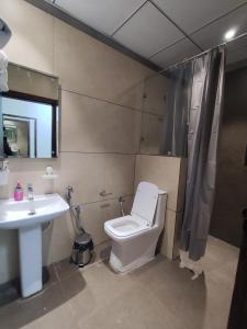 ein Badezimmer mit Toilette und Waschbecken in der Unterkunft Comfortstay Luxury Rooms in Hanamkonda + 7 Fotos