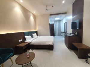 Una habitación de hotel con una cama y un televisor. en Comfortstay Luxury Rooms, en Hanamkonda