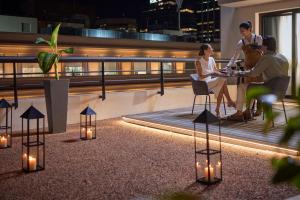 a group of people sitting at a table on a balcony at night at NH Collection Buenos Aires Jousten in Buenos Aires