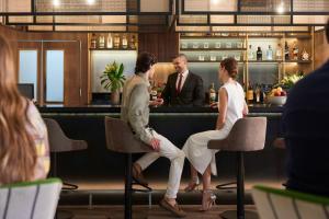 a group of people standing at a bar at NH Collection Buenos Aires Jousten in Buenos Aires