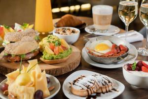 a wooden table with plates of food and drinks at NH Collection Buenos Aires Jousten in Buenos Aires
