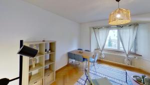 a living room with a table and chairs and a window at Apartment in the heart of Oerlikon in Zürich