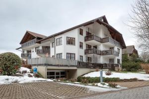 a white building with balconies on the side of it at Haus an der Gutach in Titisee-Neustadt