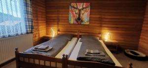 a bedroom with two beds in a wooden wall at Ferienwohnung Saussele in Arrach