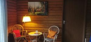 a patio with two chairs and a table and a lamp at Ferienwohnung Saussele in Arrach