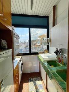 Una pequeña cocina con fregadero y ventana. en La portuense, en Castro di Lecce