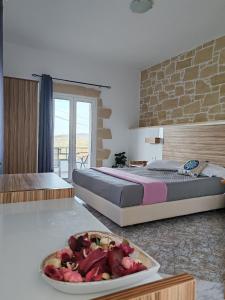 ein Schlafzimmer mit einem Bett und einer Obstschale auf einem Tisch in der Unterkunft Jacob's cottage Ideal Base for Balos & Elafonisi in Kissamos