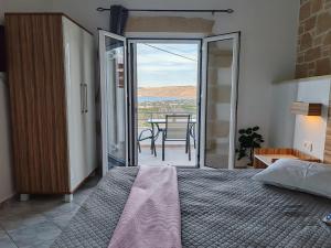 ein Schlafzimmer mit einem Bett und ein Balkon mit einem Tisch in der Unterkunft Jacob's cottage Ideal Base for Balos & Elafonisi in Kissamos