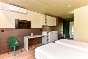 a bedroom with two beds and a desk and a chair at KARPYNĖ Restaurant & Bed & Breakfast in Gabšiai
