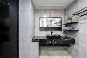ein Badezimmer mit einem schwarzen Waschbecken und einem Spiegel in der Unterkunft Summerset Saigon - The Perfect Place to Live in District 1 in Ho-Chi-Minh-Stadt + 233 Fotos