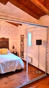 una camera da letto con un letto e una parete di vetro di Le Paradis de l'Ibie a Saint-Maurice-dʼIbie