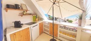 a kitchen with an umbrella and a view of the beach at Beach penthouse with rooftopbar and Starlink WiFi, spectacular 180 degrees ocean view in Santa Maria