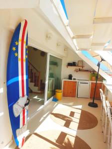 a surfboard is hanging on the wall of a room at Beach penthouse with rooftopbar and Starlink WiFi, spectacular 180 degrees ocean view in Santa Maria +75 photos