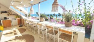a bar with chairs and a view of the beach at Beach penthouse with rooftopbar and Starlink WiFi, spectacular 180 degrees ocean view in Santa Maria
