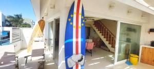a surfboard sitting on the side of a house at Beach penthouse with rooftopbar and Starlink WiFi, spectacular 180 degrees ocean view in Santa Maria