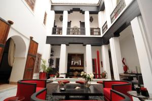 sala de estar con sillas rojas y mesa en Riad Dar Asam, en Marrakech