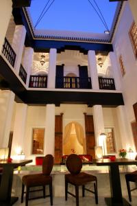 a large room with two chairs and a ceiling at Riad Dar Asam in Marrakech