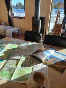 a table with a map and a cup of coffee on it at Vikendica Planinski san Blidinje in Rudo Polje