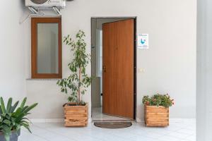 an open door with two potted plants next to it at Bellarosa alloggio Stella Marina in Quartu SantʼElena