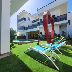 a chair with a giant red ribbon in front of a building at Chambre d'hôtes villa Burj in Ngaparou