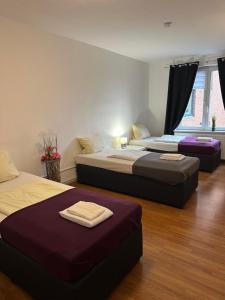 three beds in a room with two beds sidx sidx sidx at City Apartments direkt am Hauptbahnhof - Perfekt für Pendler und Monteure in Neumünster