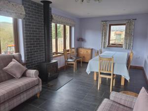 a living room with a table and a stove at Rockfoot B&B in Fintry