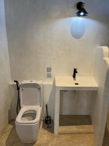 a bathroom with a toilet and a table with a light at Stopover Guest House and Restaurant in Lamu +94 photos