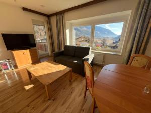 a living room with a couch and a table at Panorama Apartments Semslach in Obervellach