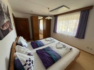 two twin beds in a room with a window at Panorama Apartments Semslach in Obervellach