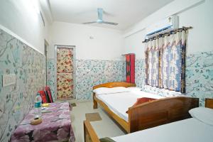 a bedroom with two beds and a window at Gouranga Guest House Mayapur ISKCON 300 MTS in mayapur