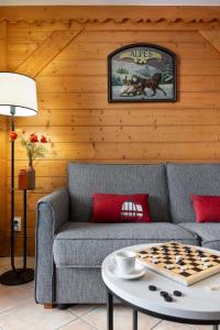 a living room with a couch and a chessboard on a table at Résidence Pierre & Vacances Premium Les Fermes De Méribel in Méribel