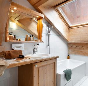 a bathroom with a sink and a bath tub at Résidence Pierre & Vacances Premium Les Fermes De Méribel in Méribel +37 photos