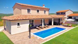 a villa with a swimming pool in front of a house at Villa Terrana near Rovinj for 6 people with private pool in Rovinjsko Selo