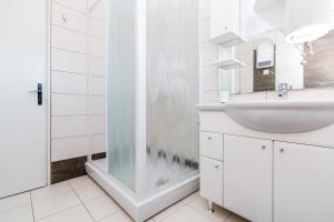a bathroom with a sink and a shower at Villa Comfort in Kaštela +12 photos