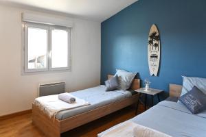 a bedroom with two beds and a window at Les Roses Trémières - A 1km de la gare garage in Saujon