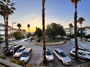 eine Gruppe von Autos, die auf einem Parkplatz mit Palmen geparkt sind in der Unterkunft La Piazzetta in Olivarella